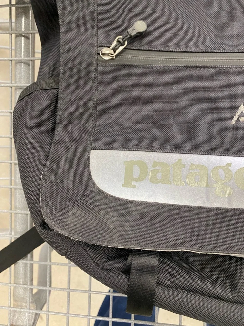 Patagonia 'Critical mass' messenger bag in black - AVEDA logo embroidered